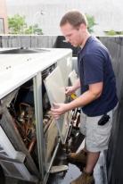 Arvada air conditioning repair man at work on a unit for a fourplex